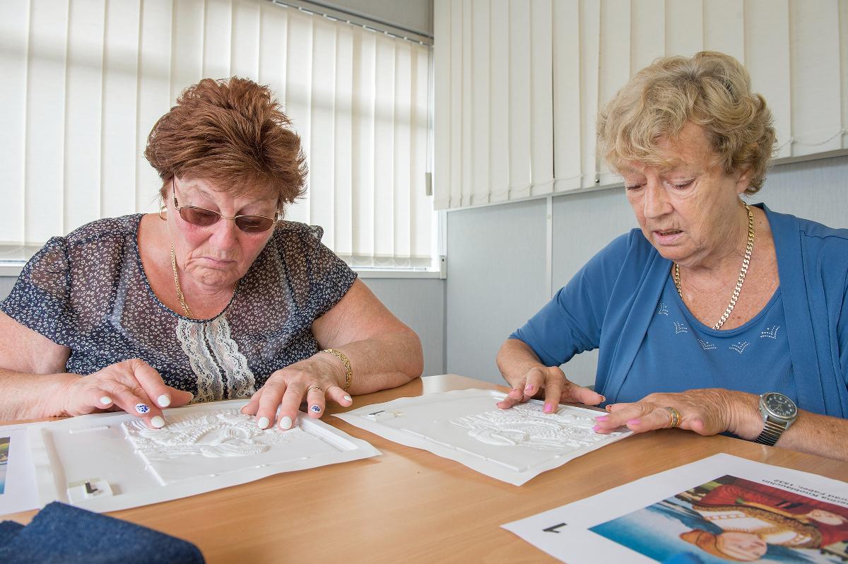 photo of two ladies using the Living Paintings and reading the images with their hands