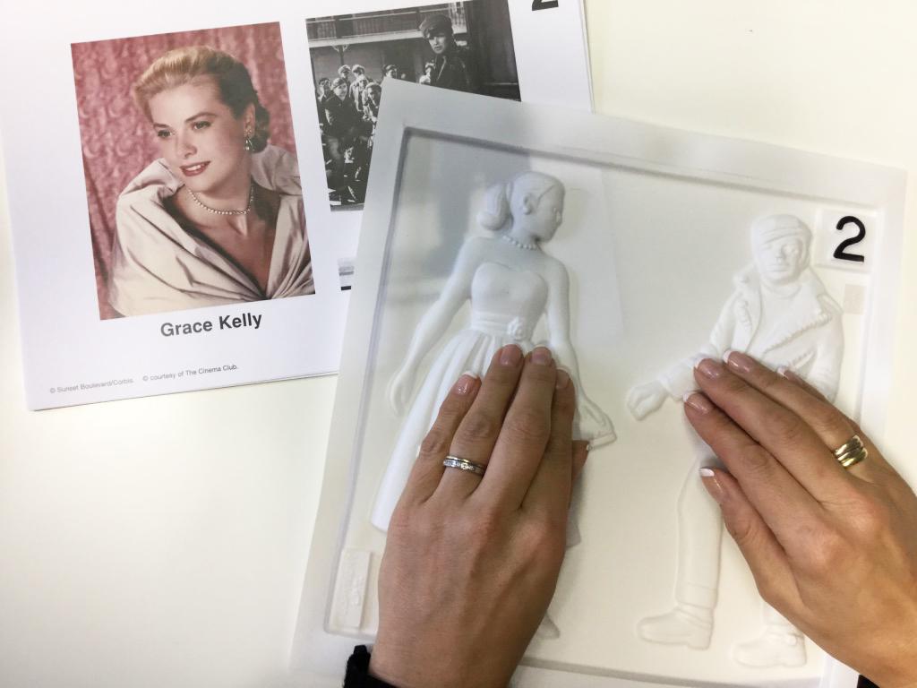 image shows a photo of Grace Kelly, and next to it a pair of hands touching an embossed image also representing Grace Kelly