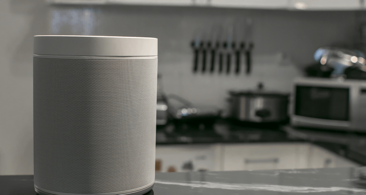 photo of a smart speaker sat on a surface in a kitchen
