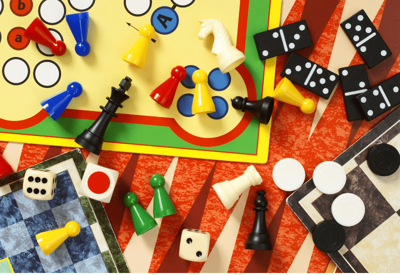 photo shows a selection of board game items such as counters, dominoes, dice, a backgammon board and more.