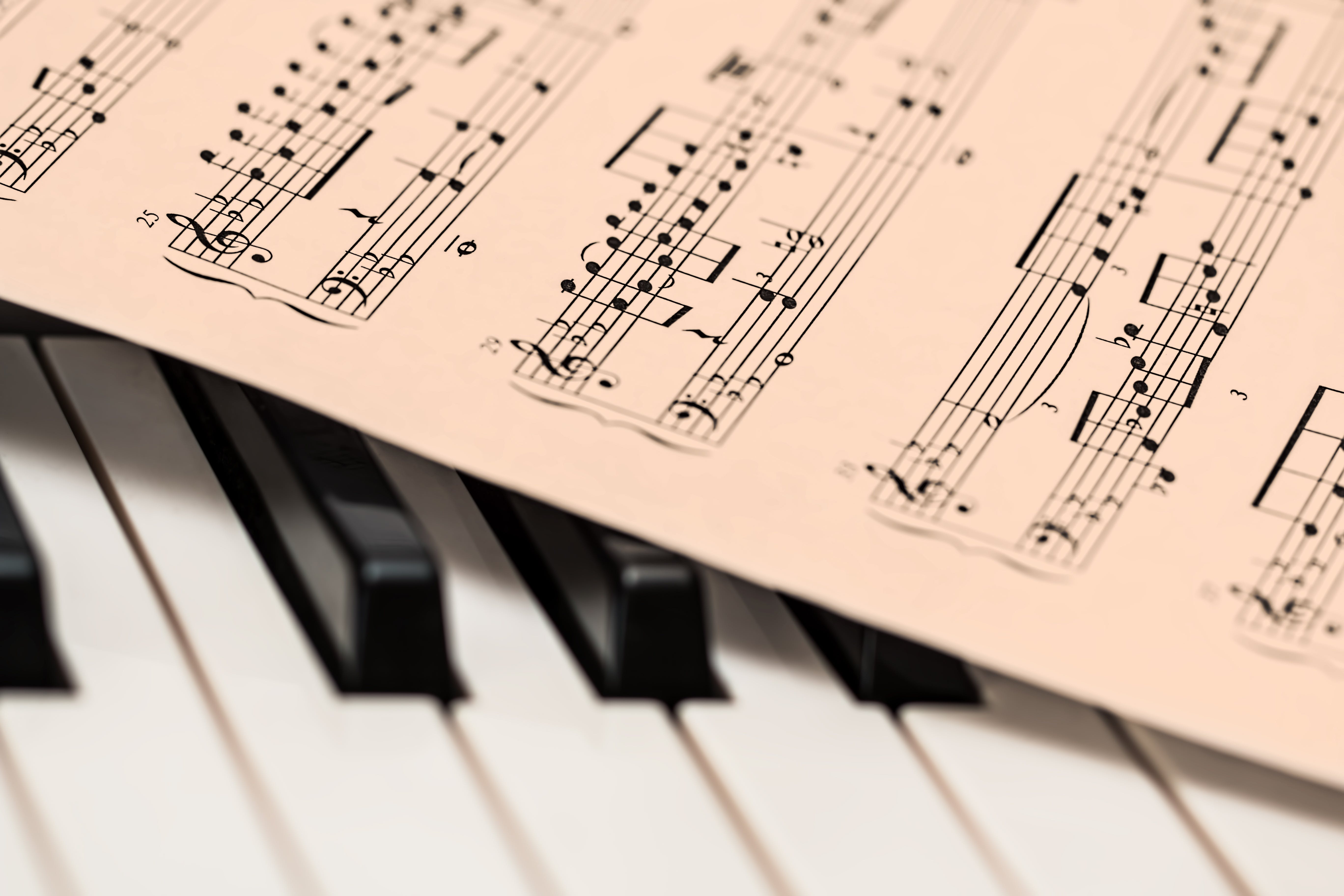a sheet of classical music laying on piano keys