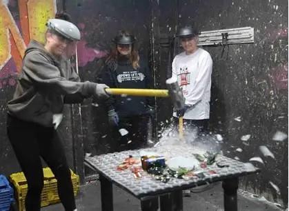 people holding hammers, smashing something on a table