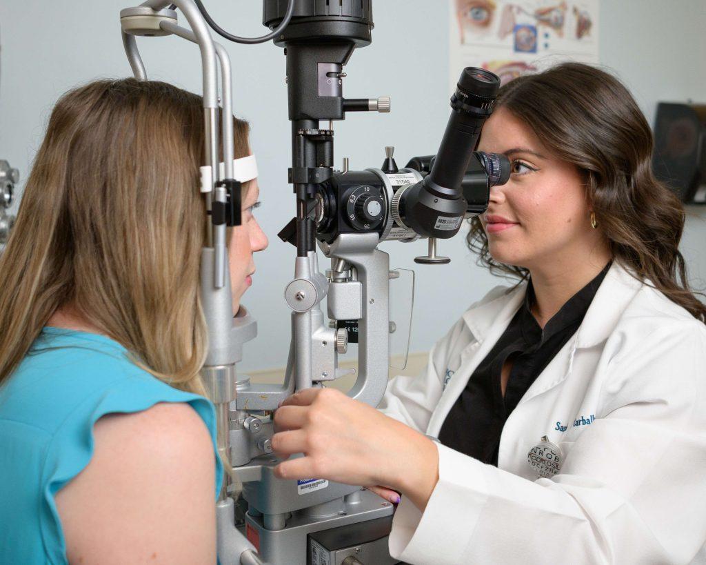 A doctor using equipment to look into someone's eye