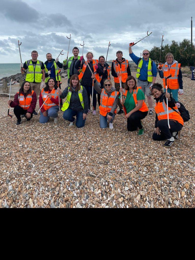 People with hi vis and litter pickers on the beach